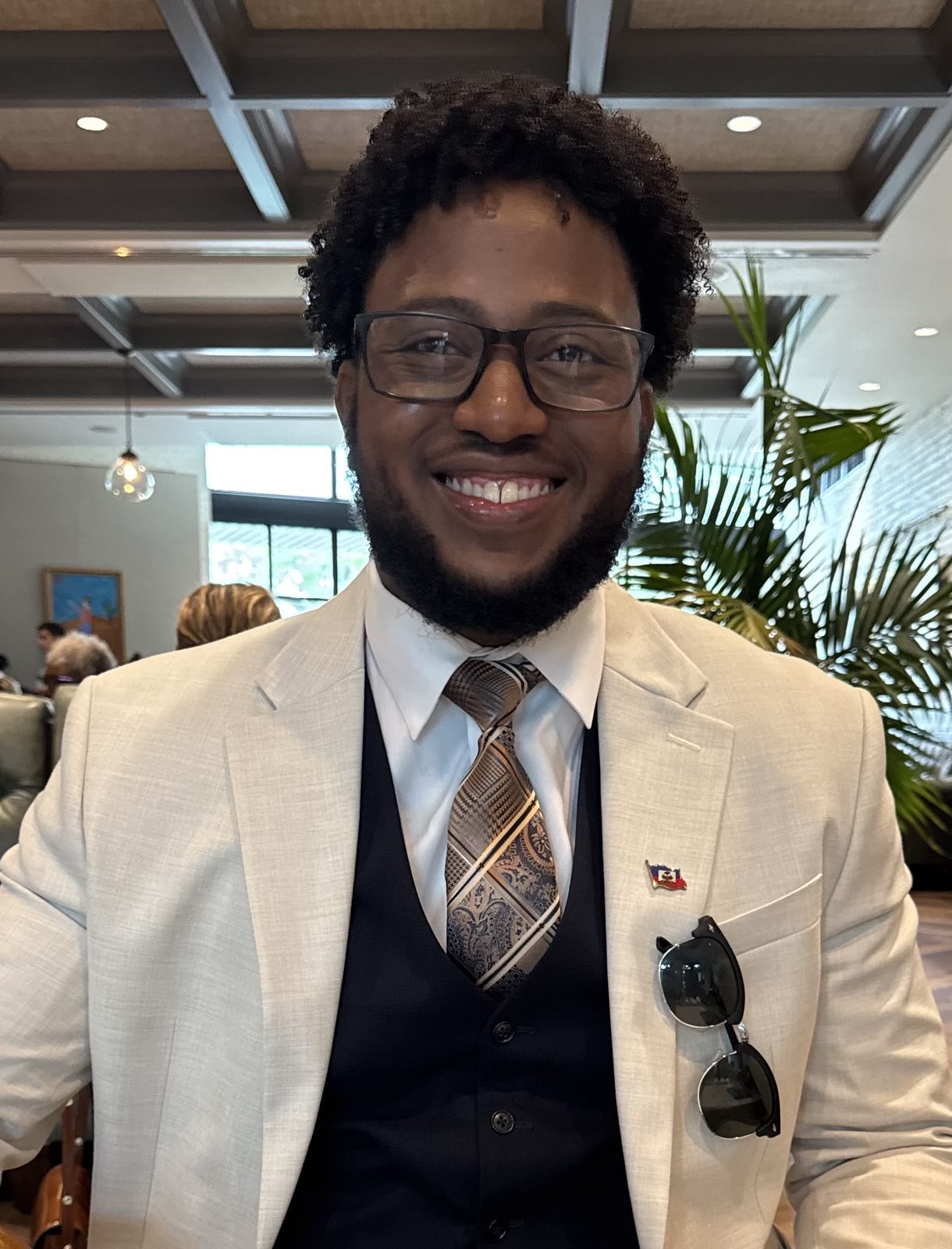 Steve B. Emile, smiling, in a light suit jacket and patterned tie